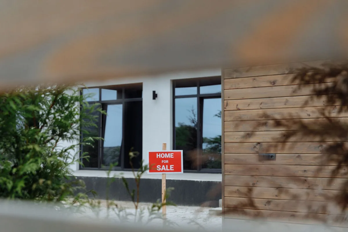 A "home for sale" sign outside a modern house, signalling more negotiating room in a softer 2026 market